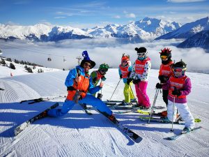 Happy Oxygene ski instructor with his students on crazy hat day